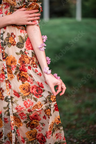 young girl walks in the park on the street in summer, hand hold dress
