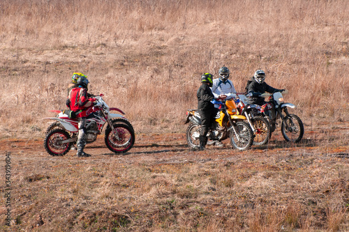 A group of athletes on cross-country bikes stopped on rough terrain.