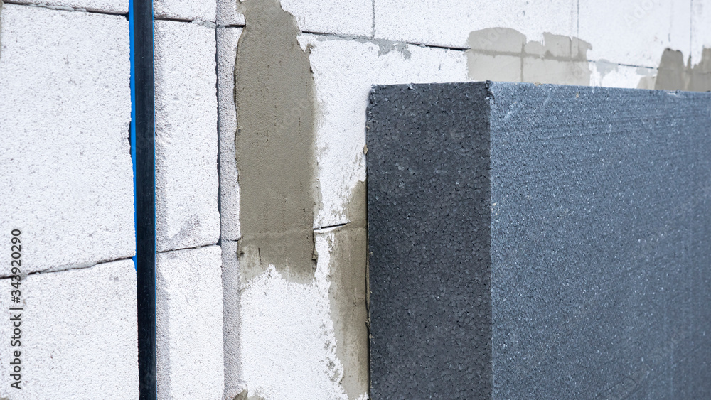 A layer of insulation on the wall of the house of aerated concrete A layer of insulation on the wall of the house of aerated concrete