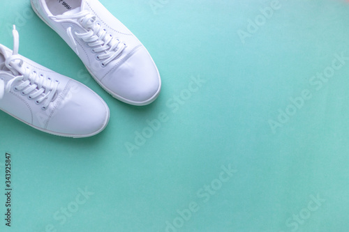 Wallpaper Mural White sneakers on light blue colour background, flat lay top view minimal background. 
 Torontodigital.ca