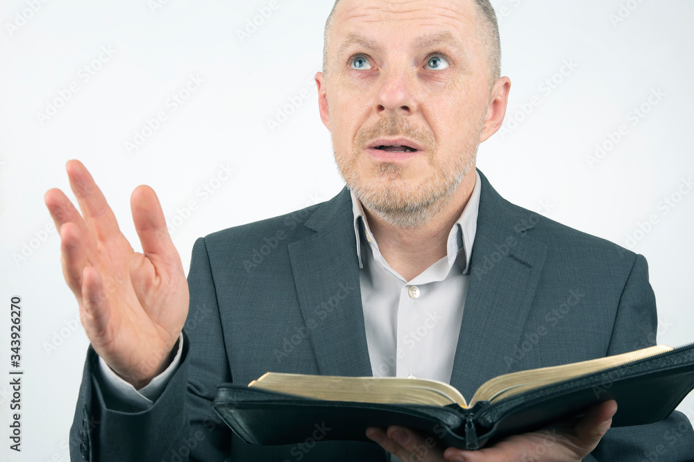 man in a business suit is reading the bible. man in a business suit is reading the bible.