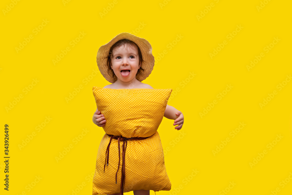 Little Girl has fun quarantine and holds a fashion show in style pillow challenge. A girl on a yellow background, wearing a yellow polka dot pillow instead of a dress and a fashionable hat. Little Girl has fun quarantine and holds a fashion show in style pillow challenge. A girl on a yellow background, wearing a yellow polka dot pillow instead of a dress and a fashionable hat.