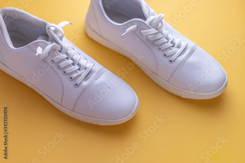 White sneakers on light blue colour background, flat lay top view minimal background. 