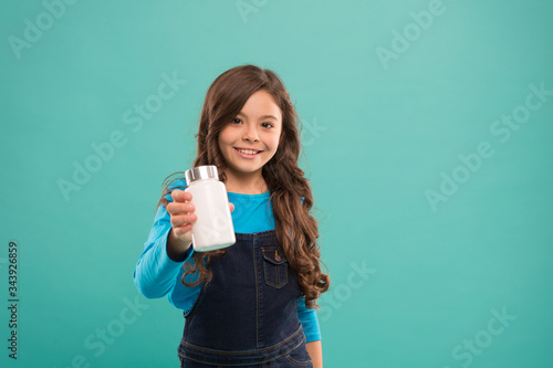 I offer this. little girl showing cream plastic bottle. products for children. kids multivitamins in container. Maintain your immunity while coronavirus pandemic. Girl going to take pill or vitamin