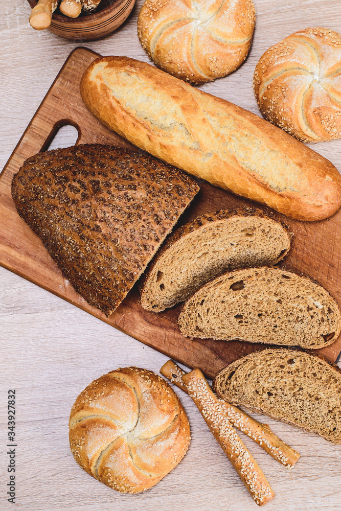 Сrisp bread with buns. French baguettes. Fresh crispbread. Bread background. Different breed  on wooden background.