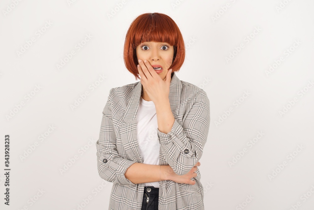Anxiety - a conceptual image of a beautiful young caucasian woman covering her mouth with her hands and standing indoors. Scared from something or someone bitting nails Anxiety - a conceptual image of a beautiful young caucasian woman covering her mouth with her hands and standing indoors. Scared from something or someone bitting nails