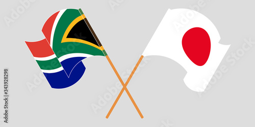 Crossed and waving flags of South Africa and Japan