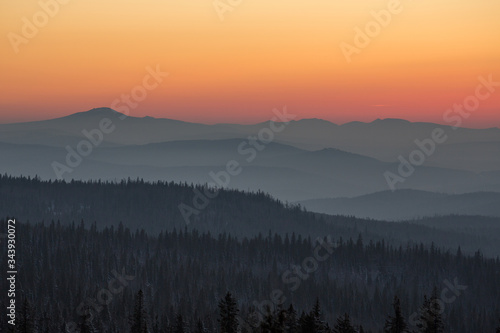 Beautiful smoky sunset in the mountains. The sun sets over the horizon 