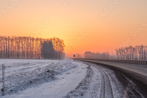 Beautiful warm sunrise on a snowy road