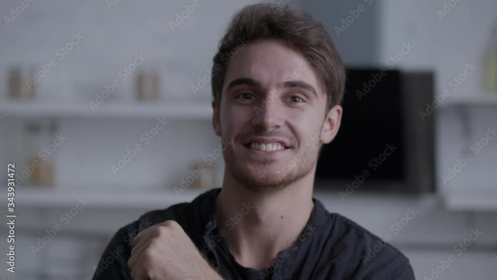 A handsome man looks at the camera and smiles broadly A handsome man looks at the camera and smiles broadly