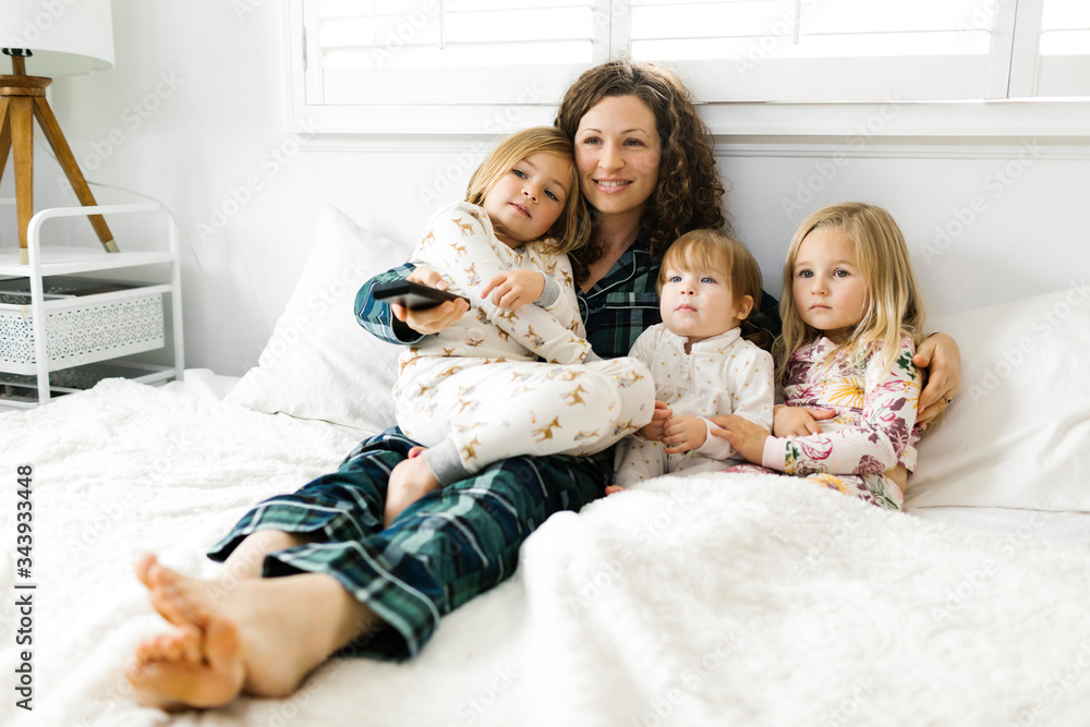 Woman sitting with her daughters on bed Woman sitting with her daughters on bed