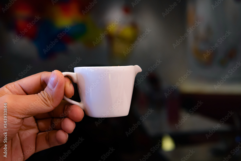 cup of coffee in hand on abstract background. cup of coffee in hand on abstract background.