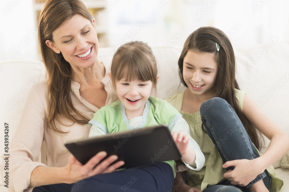 Mother and daughters (4-5,8-9) using tablet pc Mother and daughters (4-5,8-9) using tablet pc