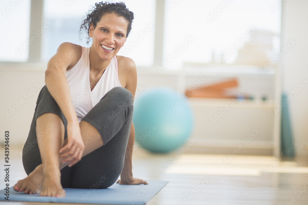 Portrait of woman sitting on exercising mat Portrait of woman sitting on exercising mat