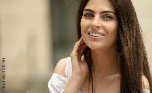 Portrait Of Young Beautiful Woman. Beautiful young brunette fashion model posing outdoor. Summer outdoor portrait. Focus on woman, blurred background.