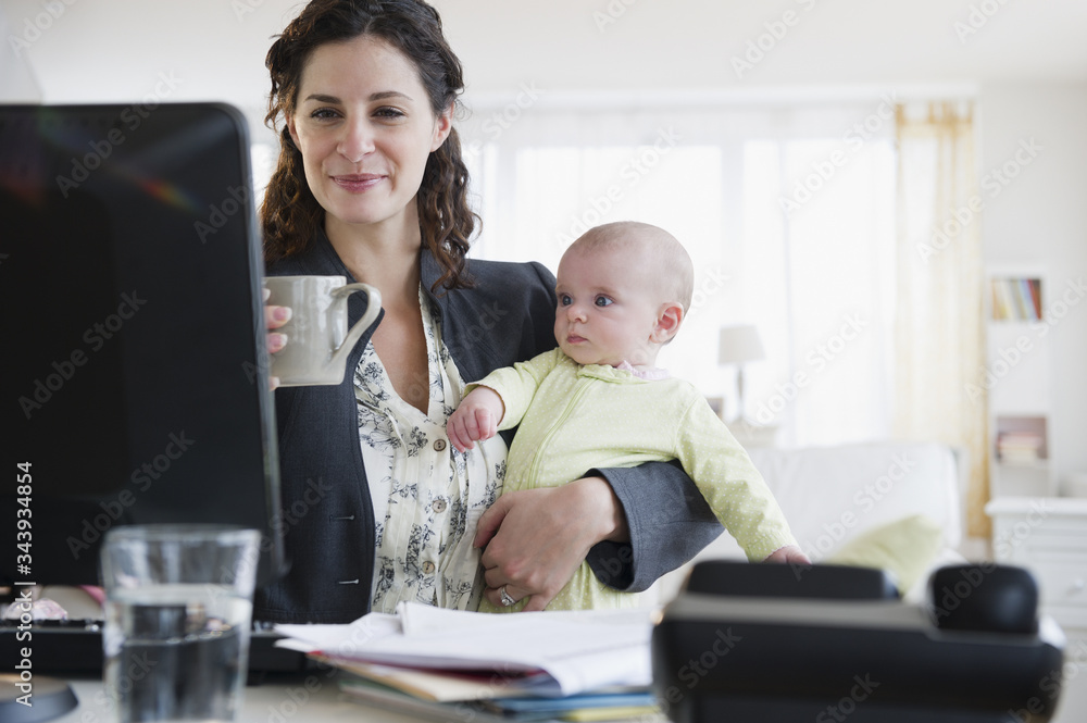 Mother with baby boy (2-5 months) working from home
