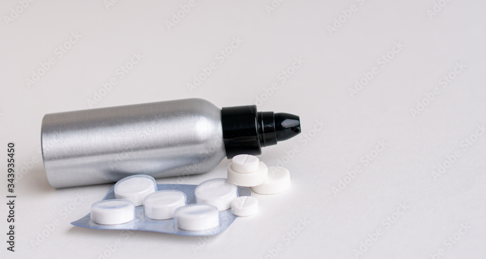 Naklejka premium Tablets fall out of the pill bottle and stand out against a gray background. Side view with space for copying. Concept of medicine