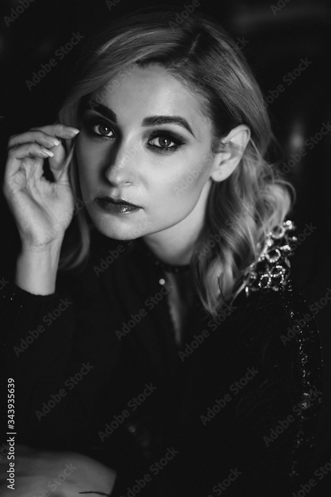 Beautiful elegant woman blonde in a black dress with feathers in retro style 1920 fashion. Soft selective focus. Black and white art photo. Beautiful elegant woman blonde in a black dress with feathers in retro style 1920 fashion. Soft selective focus. Black and white art photo.