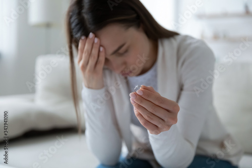 Fotografía Close up of upset young woman hold wedding ring cry distressed with divorce or m