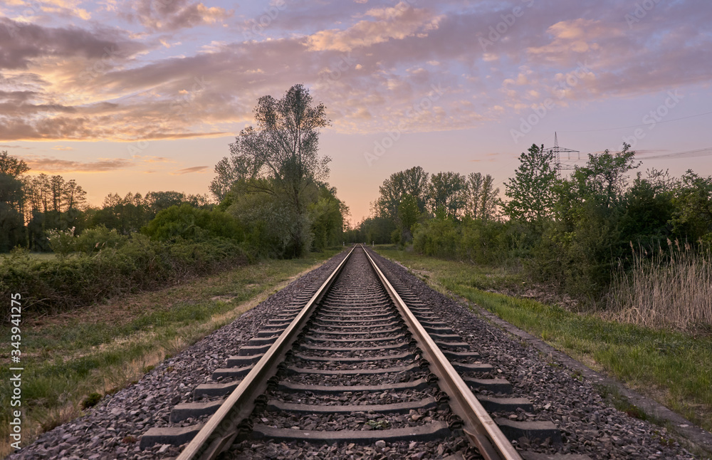 Railroad track in countryside at sunset, Rastatt, Germany