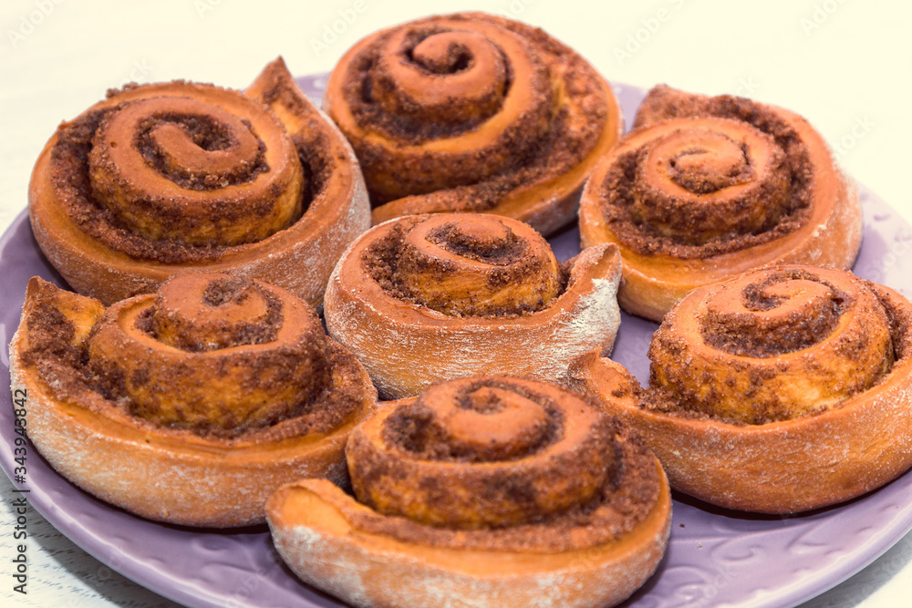 Fototapeta premium rolled bread rolls with sugar and cinnamon baked in the home kitchen as an example of home baking