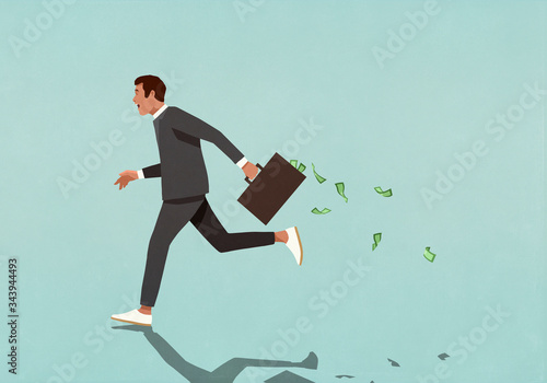Businessman running with briefcase full of cash photo