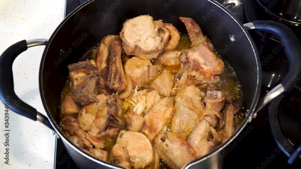 Chicken stewed meat in a pan. Rustic homemade stew meat. Top view with smoke. Cook at home Chicken stewed meat in a pan. Rustic homemade stew meat. Top view with smoke. Cook at home