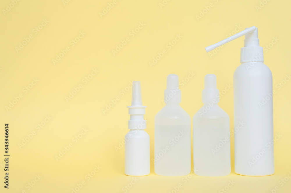Four white plastic bottle with an antiseptic on a yellow background. Healthcare and medicine concept. Personal hygiene. Four white plastic bottle with an antiseptic on a yellow background. Healthcare and medicine concept. Personal hygiene.