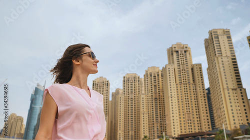 A beautiful young woman is walking in the center of Dubai.