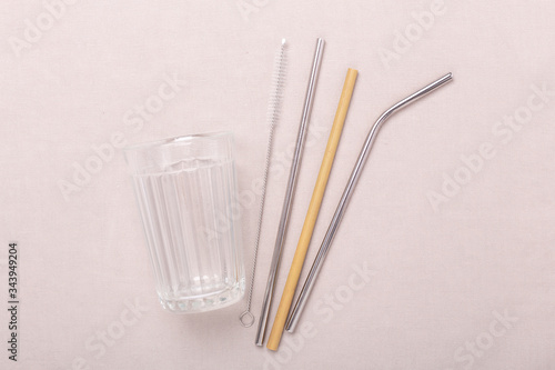 Zero waste  plastic free concept. Glass cup  metal and bamboo straw. Flat lay on textile linen background