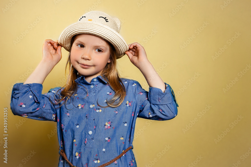 Portrait of pretty little girl in blue dress and yellow hat on yellow isolated background. Portrait of pretty little girl in blue dress and yellow hat on yellow isolated background.