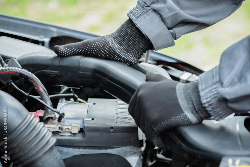 Car service worker is taking off a car air filter branch pipe close up. Car service worker is taking off a car air filter branch pipe close up.