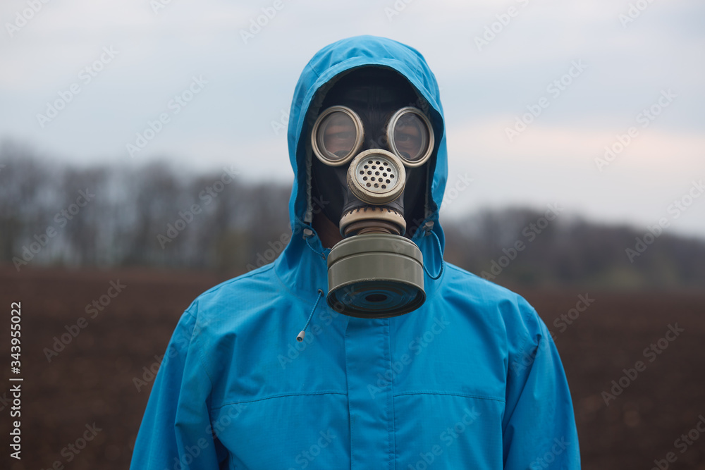 Φωτογραφία Closeup portrait of ecologist working outdoors, wearing gas mask and uniform, scientist explores surroundings, scientist works in open air, measures pollution