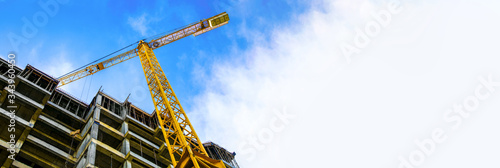 construction site and yellow crane on the background blue sky, panoramic mock-up photo
