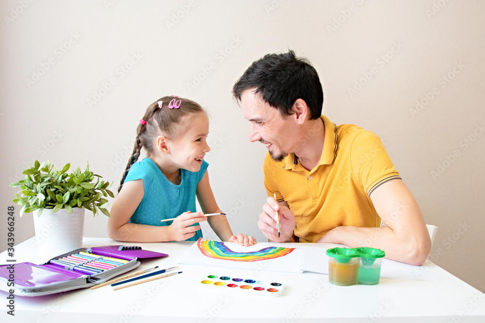 Father and daughter smile and draw a rainbow together. The father and the child and have fun drawing. Happy family. Spend more time with your loved ones Father and daughter smile and draw a rainbow together. The father and the child and have fun drawing. Happy family. Spend more time with your loved ones
