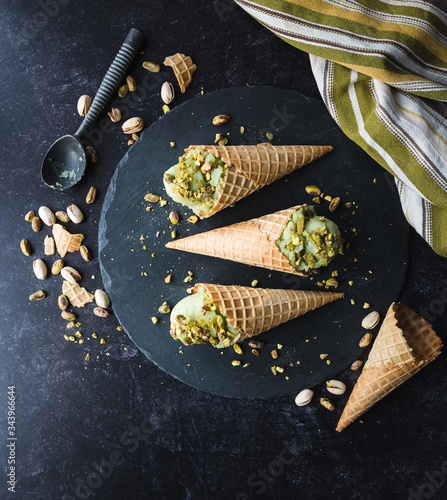 Overhead view of pistachio ice cream in cones on black background. photo