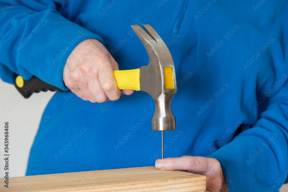 Una persona clavando un clavo con el martillo Stock Photo | Adobe Stock