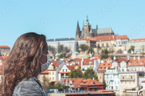 Photography Young woman with medical face mask on Charles Bridge in Prague, Czech Republic