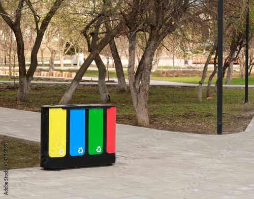 four waste sorting baskets on the city street for paper, plastic, glass and unsorted garbage