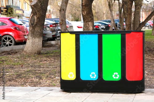 four waste sorting baskets on the city street for paper, plastic, glass and unsorted garbage