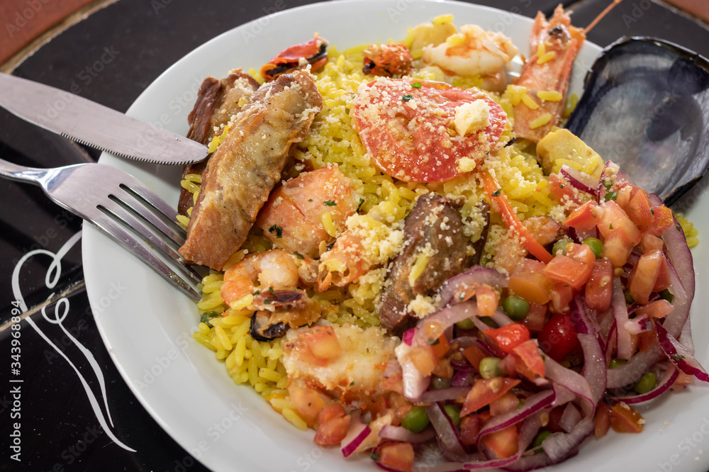 Dish made with paella, seafood and cutlery for consumption Dish made with paella, seafood and cutlery for consumption