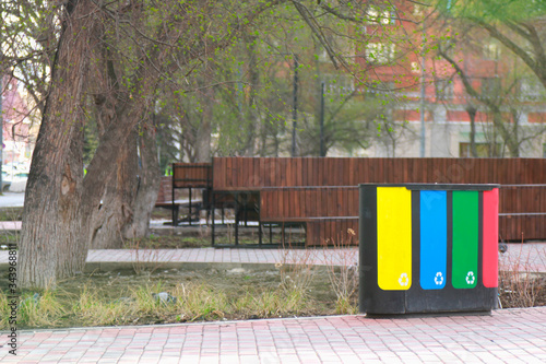 four waste sorting baskets on the city street for paper, plastic, glass and unsorted garbage