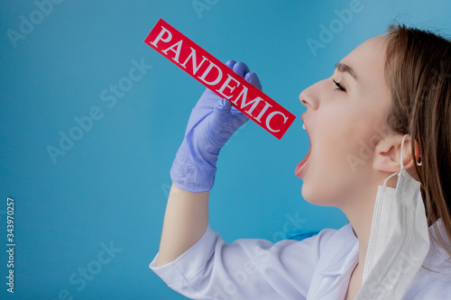 Doctor woman with surgical mask pointing to red paper with mesaage Coronavirus on blue background. World Health Organization WHO introduced new official name for Coronavirus disease named COVID-19 photo