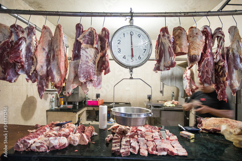 Meat and scale hanging on display at market butcher shop. photo