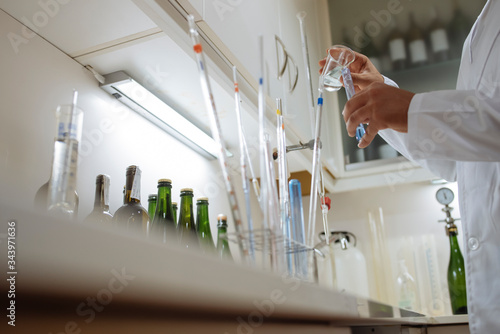 Close up of technician's hands by placing a sample on assay tube.