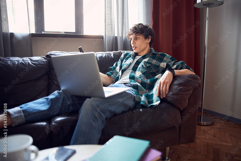 Handsome guy using laptop and cellphone at home Handsome guy using laptop and cellphone at home