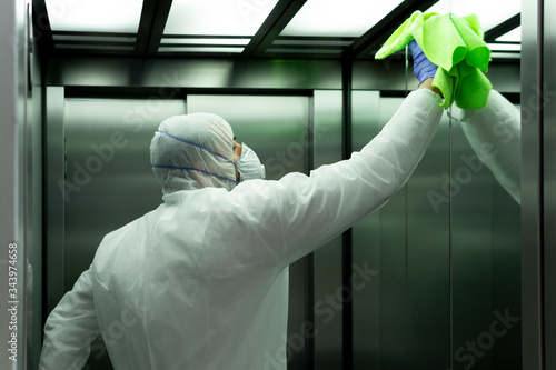 coronavirus. Worker disinfecting hospital elevator to avoid contagion. photo