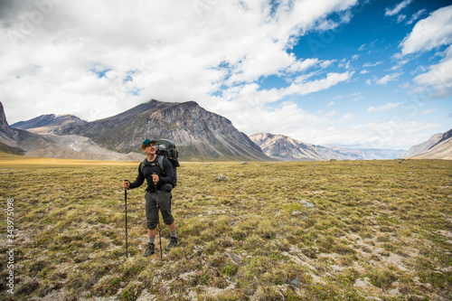 Backpacker hiking through open valley in the arctic. photo