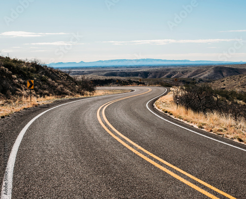 a deserted road winds through the desert near Arrey, New Mexico