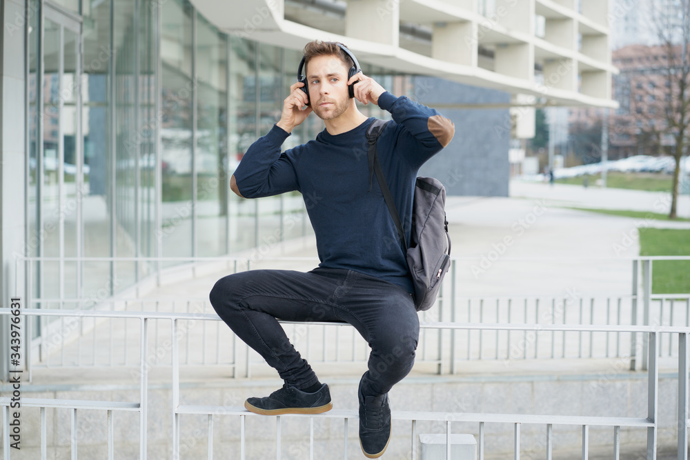 Young man with headphones on city street Young man with headphones on city street